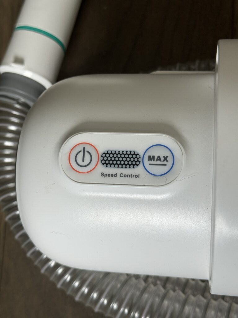 A close up of the power button and speed control settings on the Neakasa Pet Grooming Vacuum System.